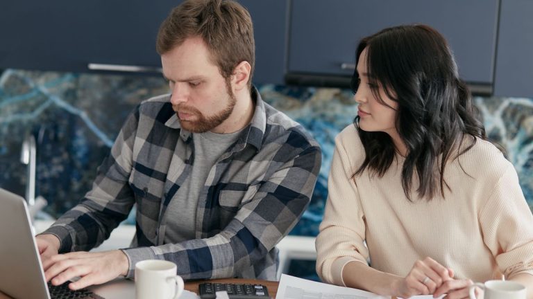طالب وأسرة يراجعون مستندات التحقق من FAFSA على حاسوب محمول